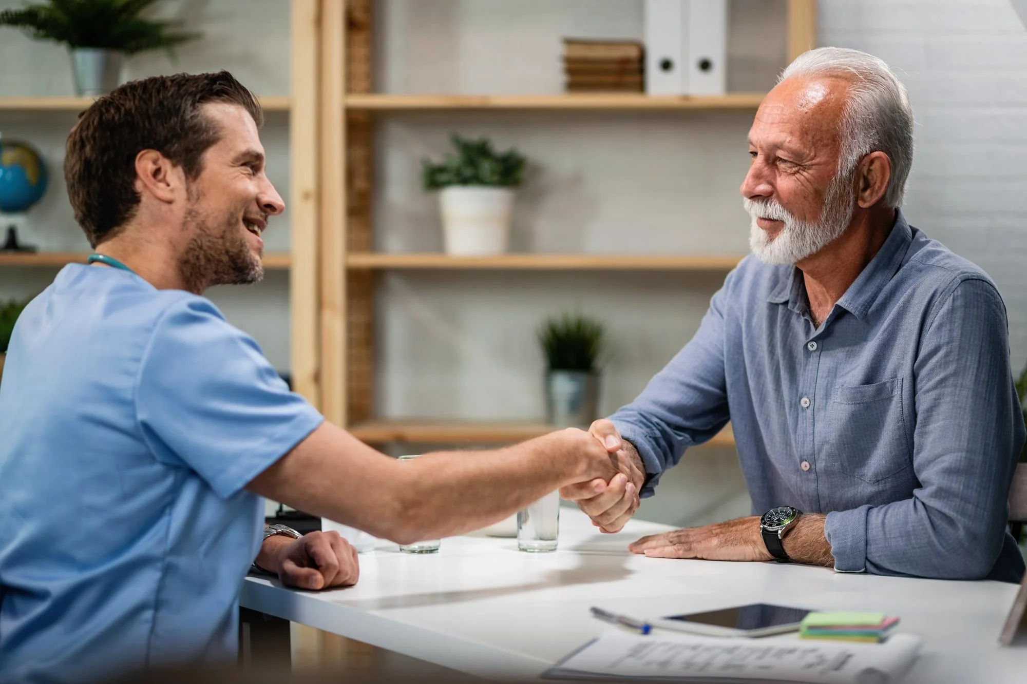 A clinician shaking hands with a patient at a home setup visit