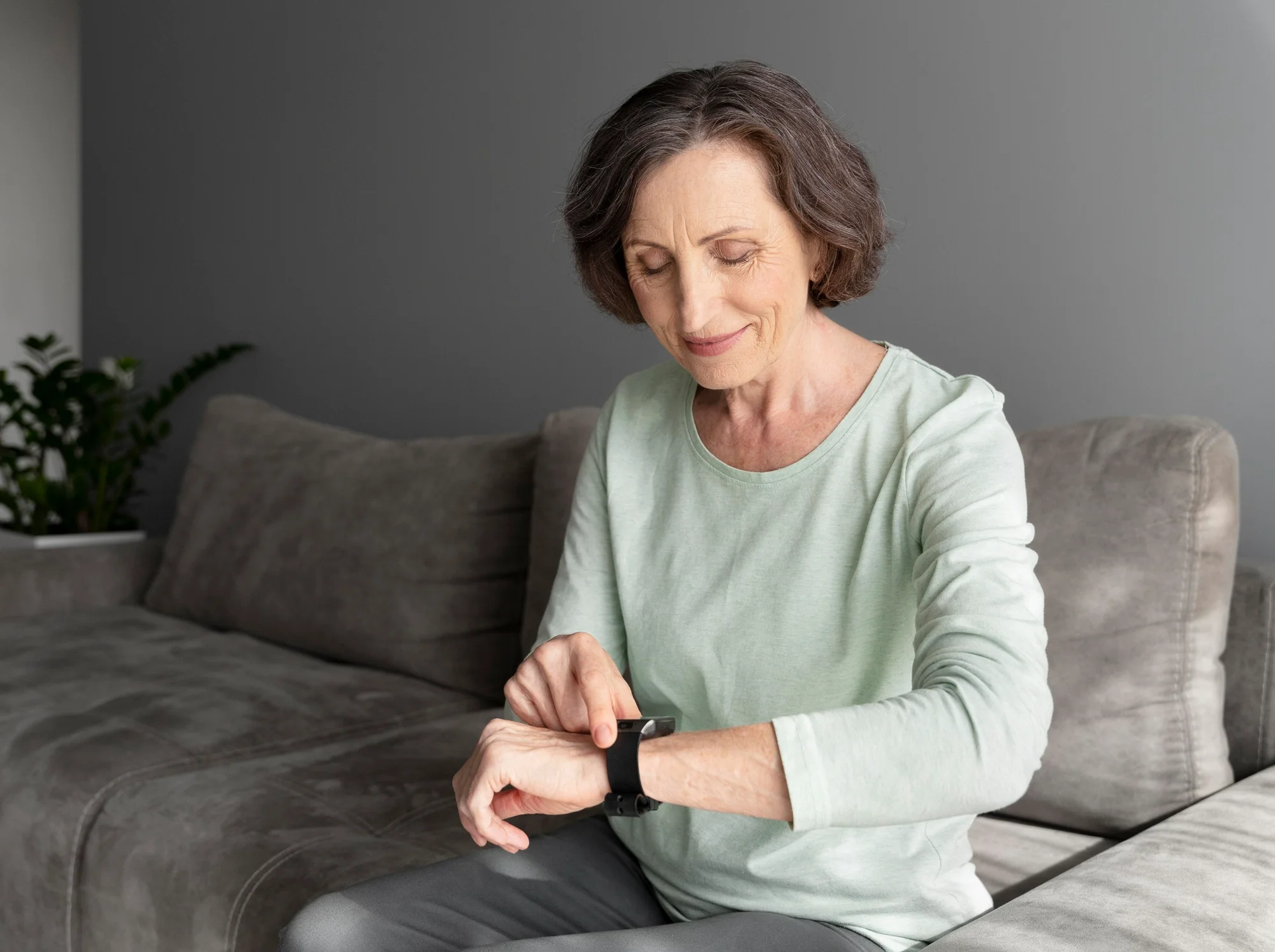 A patient checking her smartwatch at home